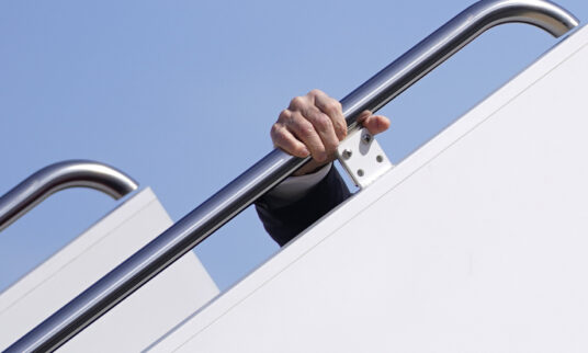 Joe Biden's hand visible holding on to the stair rail of Airforce One